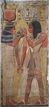 Relief of Hathor holding a man's hand and lifting her menat necklace for him to grasp