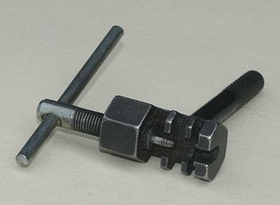 A typical chain tool. With a chain placed on the central sprocket, the screw is turned until a pin is pushed from the linkage ChainTool1.jpg