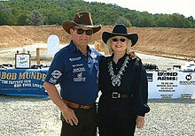 Man and woman, both wearing cowboy hats and sunglasses