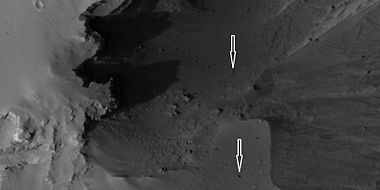 Boulders and their tracks from rolling down a slope, as seen by HiRISE under HiWish program. Arrows show two boulders at the end of their tracks. Location is Arabia quadrangle.