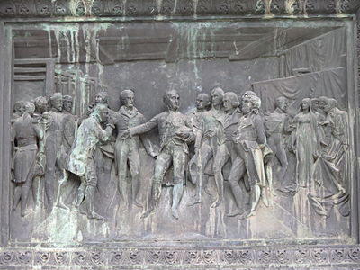 Bas-relief en bronze sur le piédestal du monument : « Le premier consul visite les manufactures du faubourg Saint-Sever et récompense le plus ancien ouvrier de l'industrie rouennaise 2 novembre 1802 ».