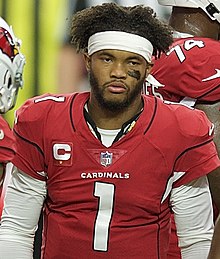 Kyler Murray from the waist up in an Arizona Cardinals jersey with no helmet.