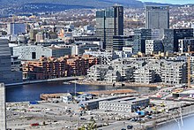 Foto einer dicht besiedelten Stadt an einer Bucht, im Hintergrund Hochhäuser