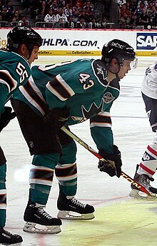 Photographie de John McCarthy avec le maillot turquoise des Sharks de San José.