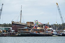 The Sydney Heritage Fleet restoration shipyard at Rozelle Bay, New South Wales. The vessels in the image include the steam tug Waratah, the harbour ferry Kanangra, and the pilot vessel John Oxley. SHF yard vessels.JPG