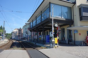 Office blocks rising from cobblestone streets; two tracks running through to the left