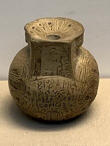 Photograph of a Greek pot in a museum case.