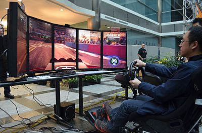 Playing a racing video game on Single Large Surface (SLS) with a 5x1 portrait display group configuration at ExtravaLANza 2012 in Toronto AMDExtravaLANzaToronto7.JPG