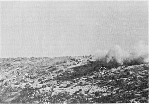 Men on a hill surrounded by explosions