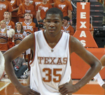 A basketball player, wearing a white jersey with the word «TEXAS» and the number 35 on the front, stands on a basketball court.