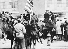 Mounted police clashing with strikers, one carrying an American flag, outside the Westinghouse electrical plant in Philadelphia in 1946 Philadelphia strike 1946.jpg