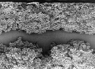 Elektro­chemisch geätzte (auf­geraute) Oberfläche einer 10 V-Niedervolt-Anodenfolie eines Aluminium-Elektrolytkondensator