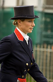 Femme, de profil, en tenue d'écuyère et portant un chapeau.