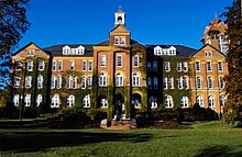 Alumni Hall at Saint Anselm College has served as a backdrop for media reports during the New Hampshire primary. Alumni Hall 1889 Sun.jpg