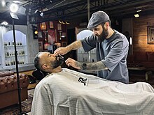 An Iranian barber shaping his costumer's beard in Ahvaz, Iran [?]2022 Iranian barber.jpg