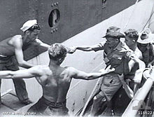 An emaciated Australian ex-POW from Batu Lintang camp being helped aboard Wanganella by naval ratings Awm118522.jpg