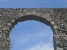 Vue de la voûte d'une arche d'un aqueduc, en briques et pierres alternées.