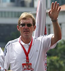 Man in a white shirt, wearing sunglasses.