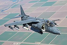 Front-view of gray jet aircraft executing a hover. The huge engine inlets are on both sides of the fuselage