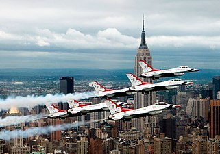 Sex F-16 Fighting Falcon plan i formation över New York med Empire State Building i bakgrunden.