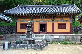 Photographie de la cour d'un temple. Un bâtiment d'un étage est visible dans le fond, ainsi qu'une statu dans la cour.