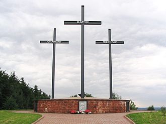 A Memorial consisting o three crosses staundin on a lairge brick pedestal. Each cross bears a name - Katyn, Kharkiv, or Mednoye.