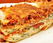 O vedere de aproape a lasagnei care prezintă straturile de sos, brânză și alte ingrediente