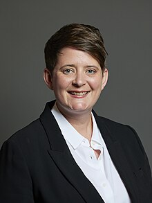 Official portrait of Olivia Bailey, she has short dark hair and is smiling at the camera.