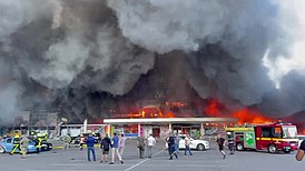 Пожарные и спасатели прибывают к охваченному огнём торговому центру