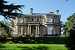 a grass slope in front of a small mansion