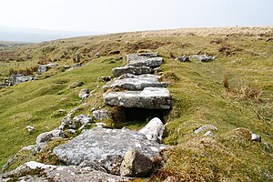 A line of flat stones on the ground covering a shallow channel