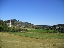 Photographie en couleurs d'un site d'un vallon entouré par des collines.