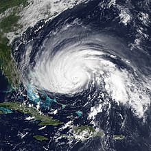 Satellite image of Hurricane Gloria as it is located well east of Florida, with a pinhole eye and a convective band pattern which is slightly elongated longitudinally, although the overall circulation of the storm is still tight and intense.