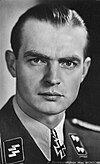 A man wearing a military uniform with an Iron Cross displayed at the front of his uniform collar.