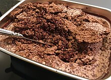 Untempered chocolate mass that has been left to cool at room temperature after conching, showing large cocoa butter crystals and a crumbly consistency. Untempered chocolate.jpg