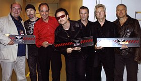 U2, their manager Paul McGuinness, and concert promoters Gerard Drouot and Michael Deeny pose with copies of the album before a 2005 concert in France Gerard-drouot-U2-stade-de-france.jpg