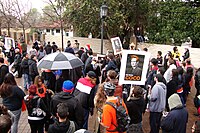 A gathering crowd where some people wear orange and hold signs that say "I'm With Coco".