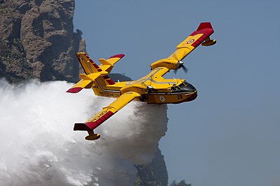 Sebuah pesawat pemadam Bombardier 415 menyemburkan air untuk memadamkan kebakaran hutan di Italia