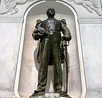 Bronze statue of a man standing with his hand on his sword at his hip