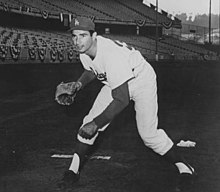 "A man in the Los Angeles Dodgers home uniform and cap with a glove, posing in fielding position."