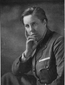 A black and white image of a woman with a short, neatly brushed haircut, facing to the front but angled to her right. She is in a dark uniform jacket, she had her chin perched in her left hand