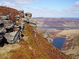 A stack of rocks with a lake beyond