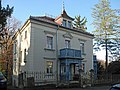 Villa mit massiv untersetzter Ecklaube und Einfriedung