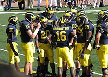 2007 Michigan Wolverines football team huddle with Mario Manningham (86), Ryan Mallett (15), Mike Hart (20), Jake Long (77), Adrian Arrington (16), Mike Massey (83), Justin Boren (65), Carson Butler (85), and Stephen Schilling (52) against Penn State 20070922 Michigan huddle.jpg