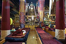 Temple interior with pillars, resting places and a statue