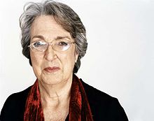 Head and shoulders photograph of a 74-year-old woman wearing glasses