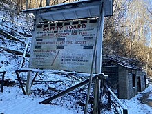 Image of white sign in snow. Text on sign says safety board.