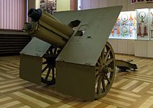 A colour photograph of an artillery piece in a museum building