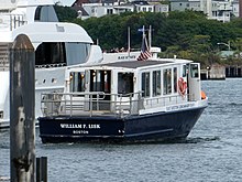 A small ferry in an urban harbor