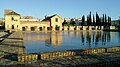 Reservoir of the al-Buḥayra gardens in Seville, with remains of palace structure behind it (partly occupied by later building)